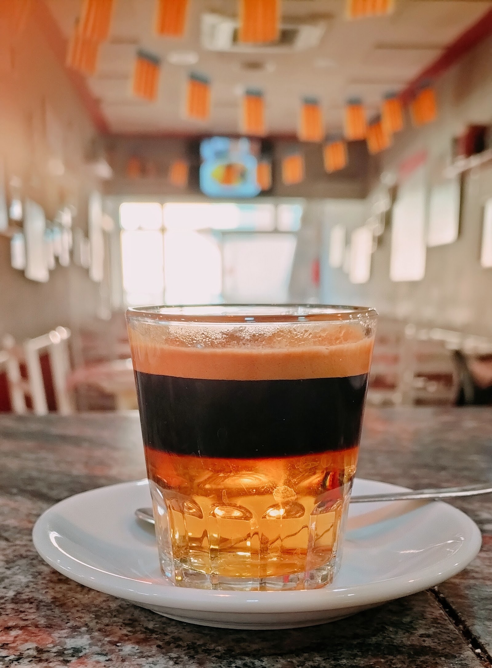 Vaso de café con licor sobre plato